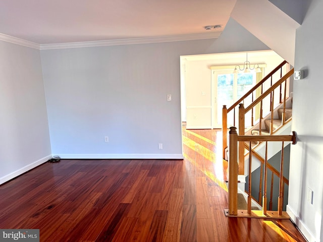 empty room with a chandelier, wood-type flooring, and ornamental molding