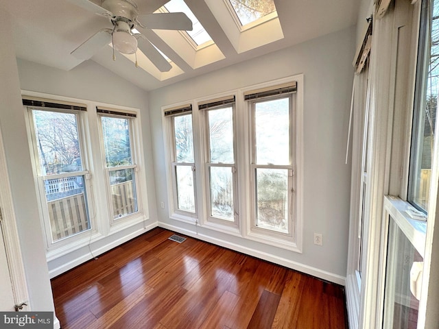 unfurnished sunroom featuring lofted ceiling with skylight and ceiling fan