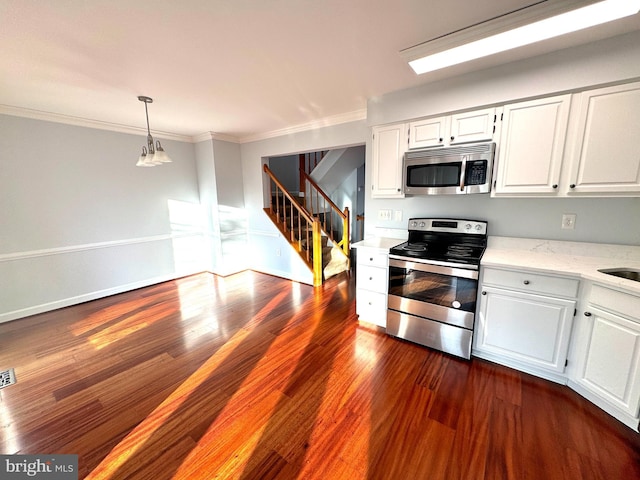 kitchen with white cabinets, appliances with stainless steel finishes, dark hardwood / wood-style floors, and ornamental molding