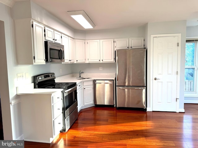 kitchen with white cabinets, appliances with stainless steel finishes, dark wood-type flooring, and sink