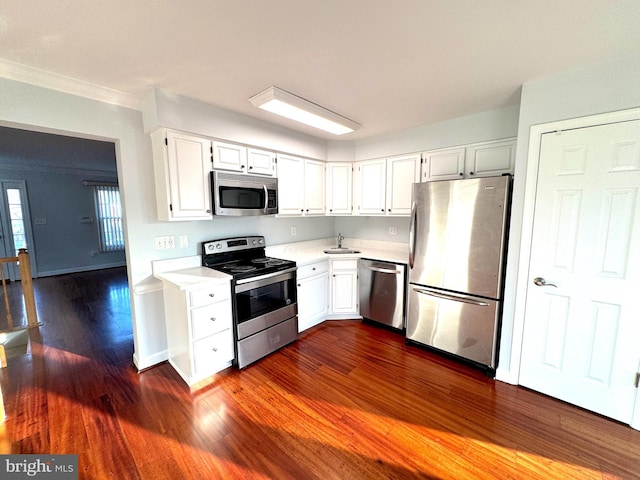 kitchen featuring white cabinets, sink, stainless steel appliances, and dark wood-type flooring