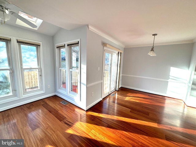 spare room featuring hardwood / wood-style floors, ceiling fan, ornamental molding, and lofted ceiling with skylight