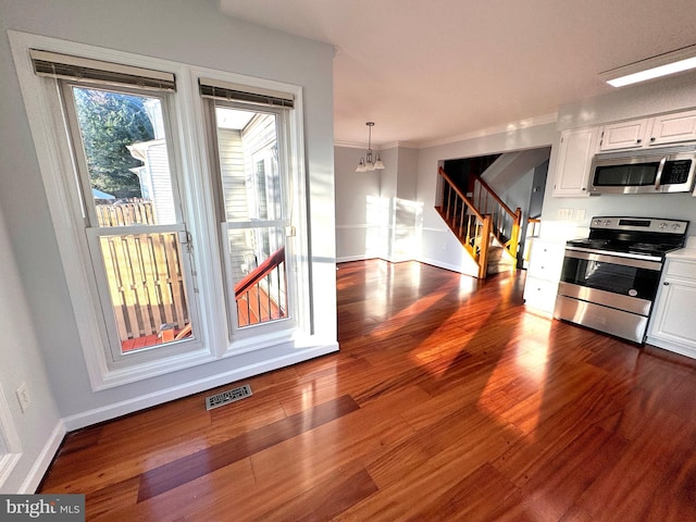 kitchen with white cabinets, dark hardwood / wood-style flooring, and stainless steel appliances