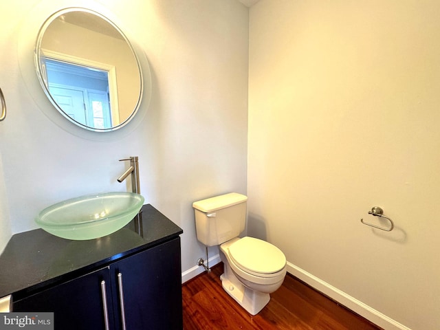 bathroom featuring wood-type flooring, vanity, and toilet