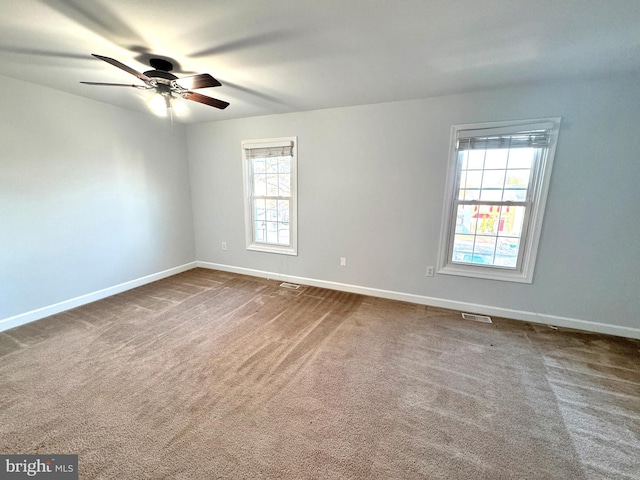 unfurnished room with ceiling fan, a healthy amount of sunlight, and carpet floors