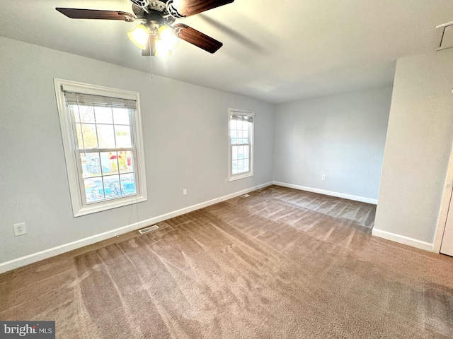 carpeted spare room with plenty of natural light and ceiling fan