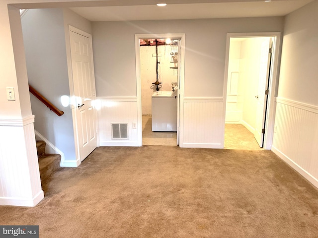 empty room featuring light carpet and washer / clothes dryer