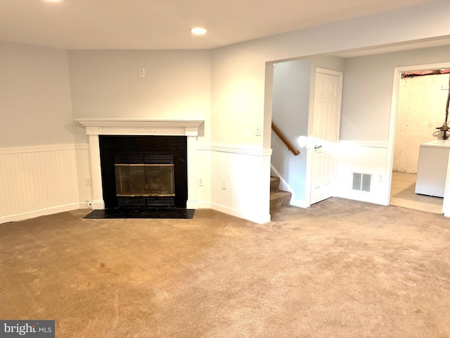 unfurnished living room with carpet flooring and washer / clothes dryer