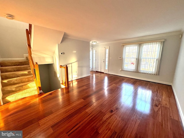 unfurnished living room with wood-type flooring and crown molding