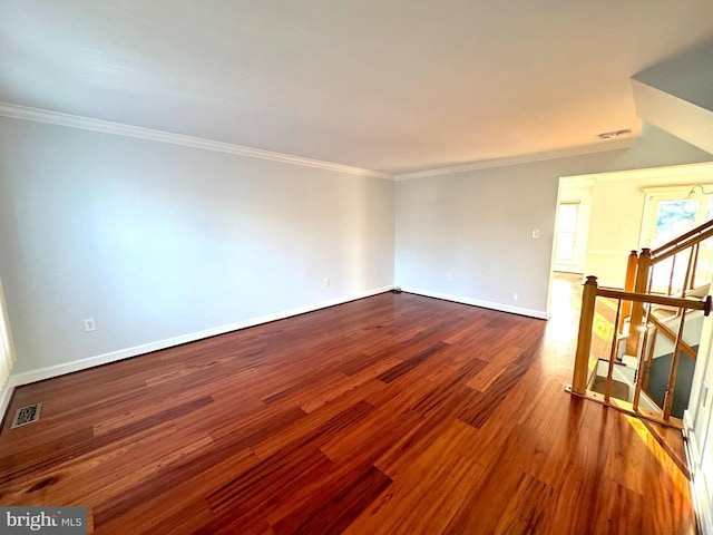 empty room with hardwood / wood-style floors and crown molding