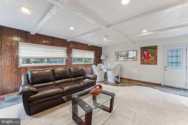 living room with coffered ceiling, beamed ceiling, wooden walls, and a textured ceiling