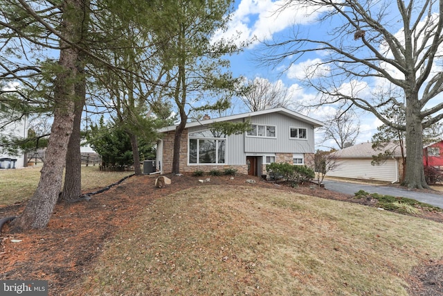 tri-level home featuring a front lawn and central AC