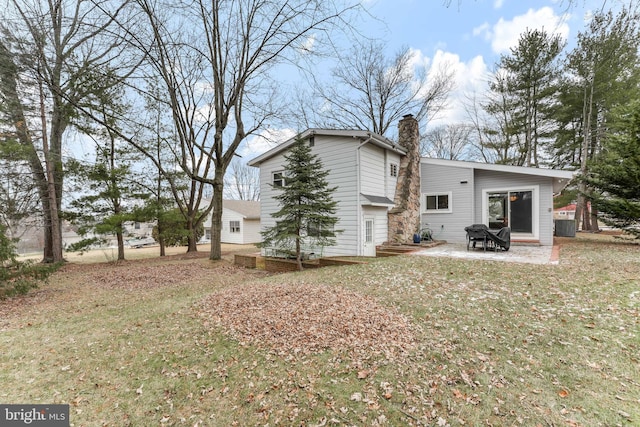 rear view of property with central AC unit, a patio area, and a yard