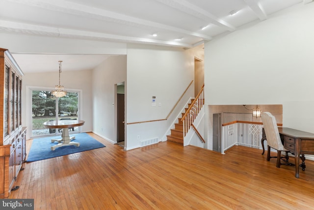 interior space featuring lofted ceiling with beams, an inviting chandelier, and light hardwood / wood-style floors