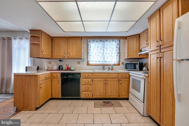 kitchen with backsplash, white appliances, and sink