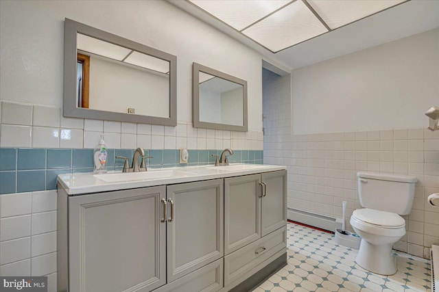 bathroom with vanity, toilet, tile walls, and a baseboard radiator