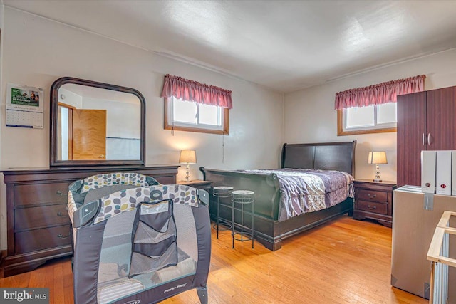 bedroom with multiple windows and light wood-type flooring