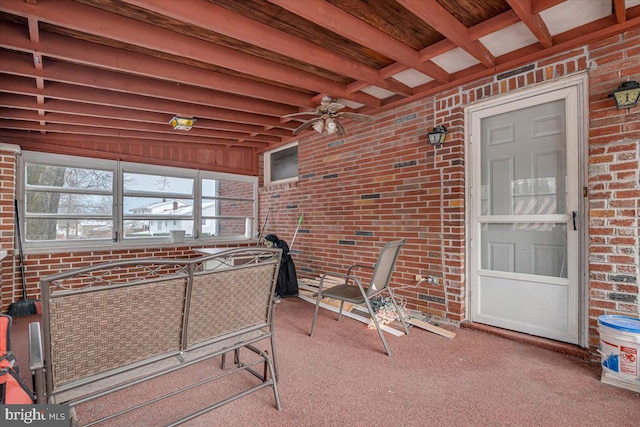 sunroom with ceiling fan and beam ceiling