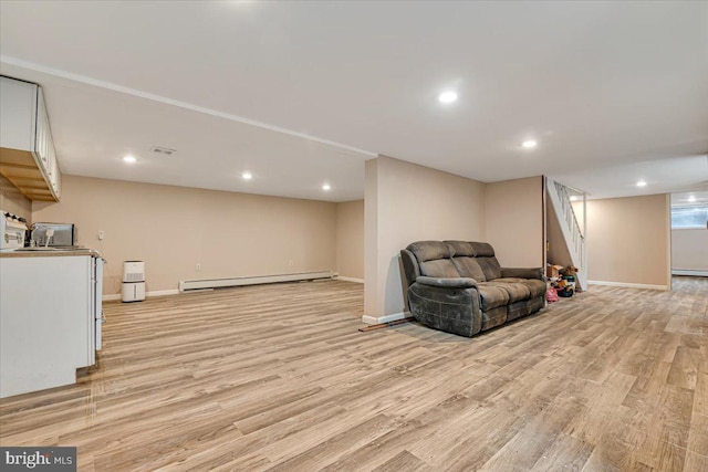 sitting room with sink, light wood-type flooring, and baseboard heating