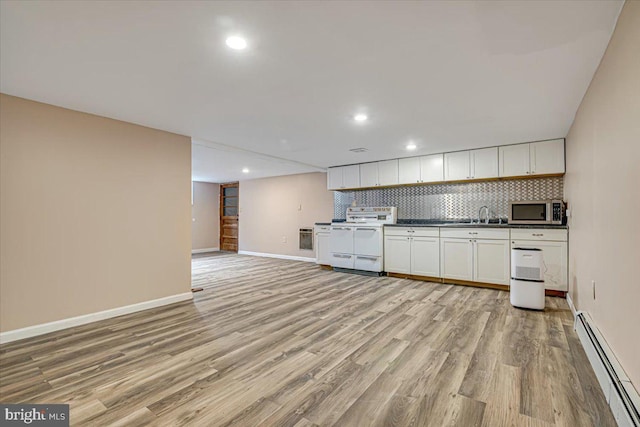 kitchen featuring light wood-type flooring, electric range, a baseboard radiator, and white cabinetry