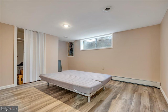 bedroom featuring a baseboard radiator and light hardwood / wood-style floors