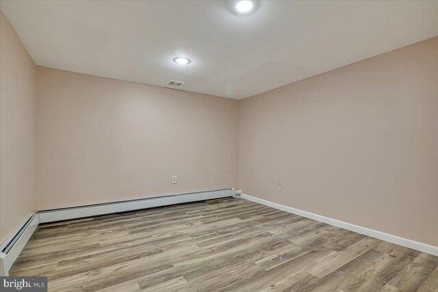 spare room featuring light wood-type flooring and baseboard heating