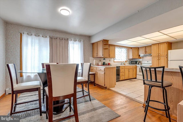 kitchen featuring light hardwood / wood-style floors, white appliances, and sink