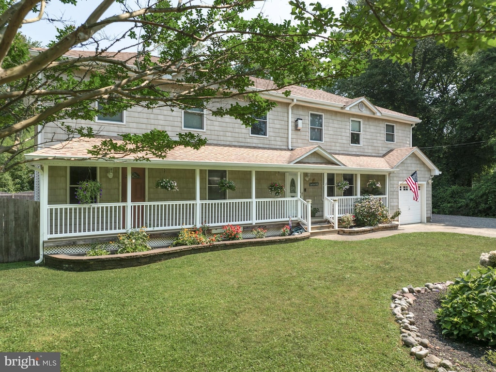 view of front of house with a front lawn, a porch, and a garage