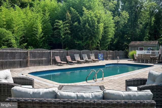 view of swimming pool with a patio area and an outdoor structure