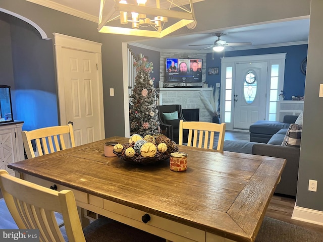 dining space featuring ceiling fan with notable chandelier, dark wood-type flooring, and ornamental molding