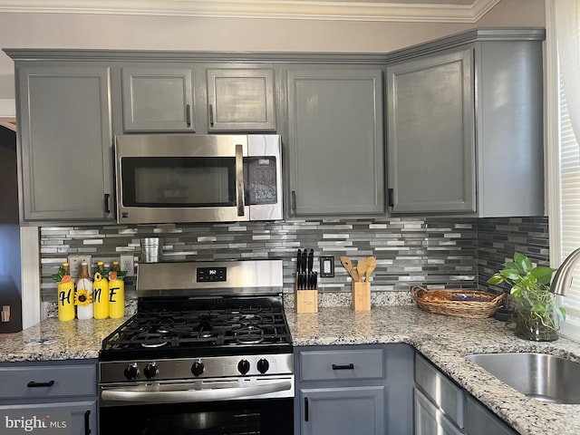 kitchen featuring gray cabinetry, backsplash, sink, and stainless steel appliances