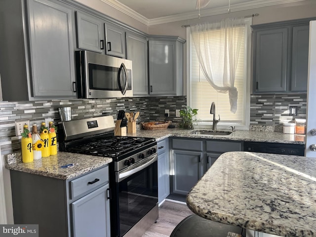 kitchen featuring light stone counters, sink, plenty of natural light, and stainless steel appliances