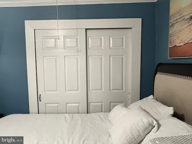 bedroom with ornamental molding and a closet