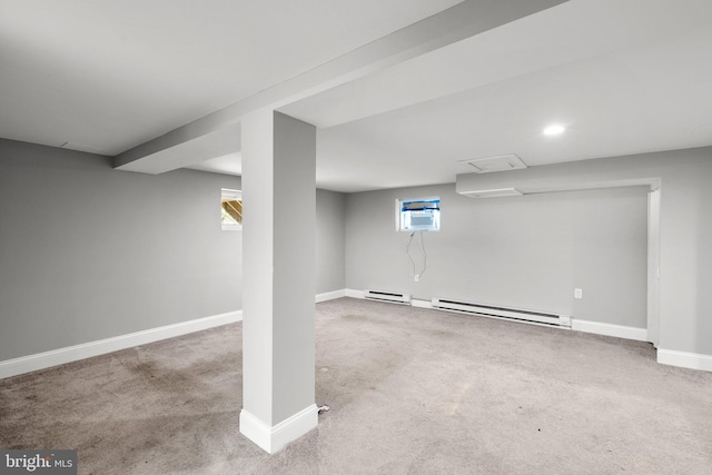 basement with carpet floors, a baseboard radiator, and a wall mounted AC