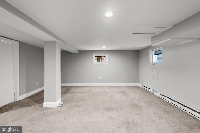 basement with carpet flooring, a wall unit AC, and baseboard heating