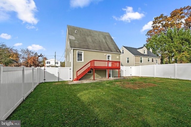 rear view of property with a lawn and a wooden deck