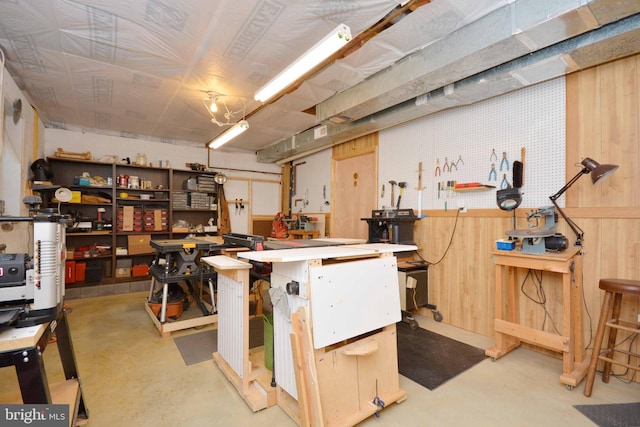 basement with a workshop area and wooden walls