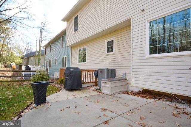 rear view of property featuring central air condition unit and a patio