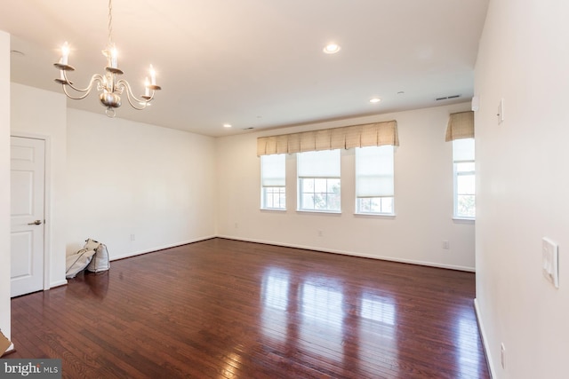 unfurnished room with dark hardwood / wood-style floors and a notable chandelier