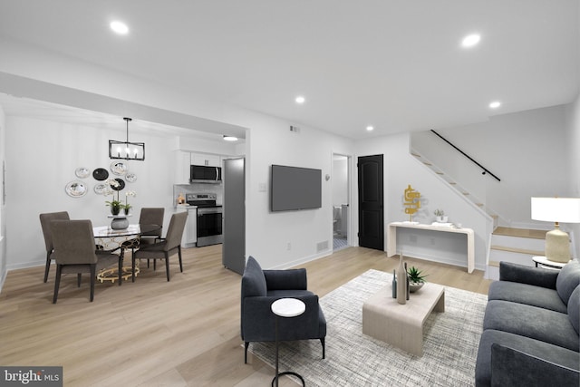 living room featuring a notable chandelier and light hardwood / wood-style floors