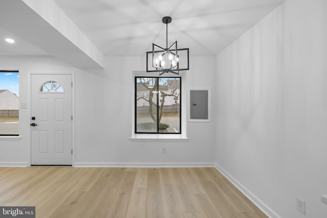 entrance foyer featuring electric panel, a chandelier, and light hardwood / wood-style floors