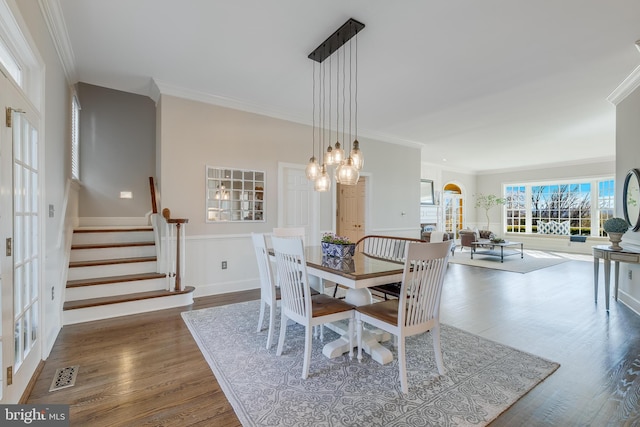 dining room with a chandelier, crown molding, and dark wood-type flooring