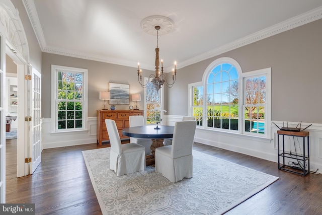 dining room with a notable chandelier, dark hardwood / wood-style floors, and ornamental molding