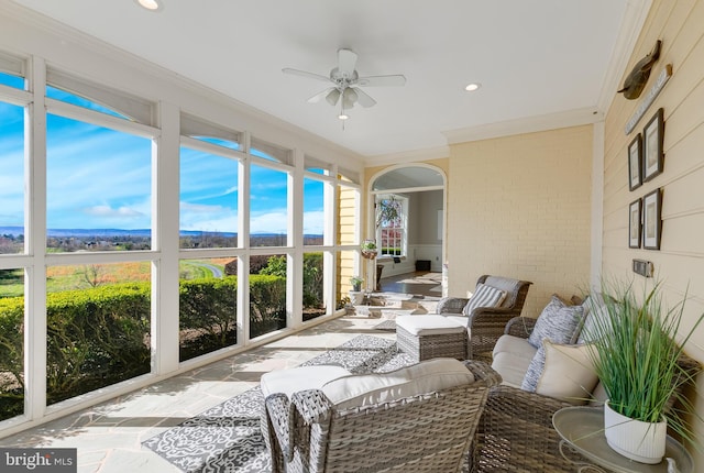 sunroom / solarium with ceiling fan and a rural view