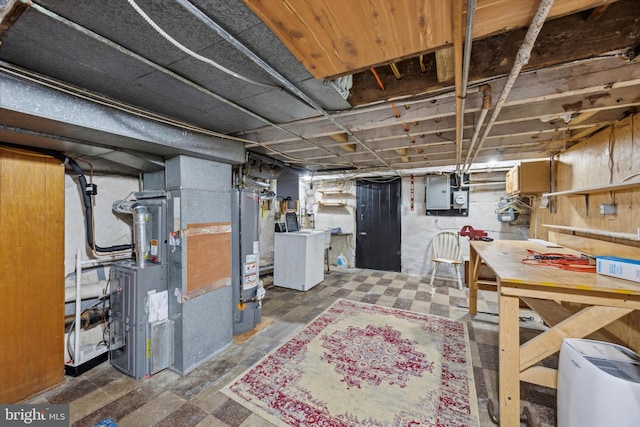 basement with gas water heater, a workshop area, electric panel, heating unit, and washer / dryer