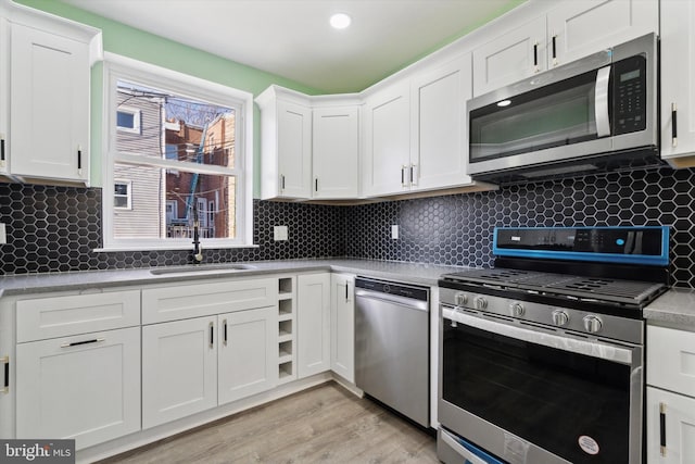 kitchen featuring backsplash, white cabinetry, and stainless steel appliances