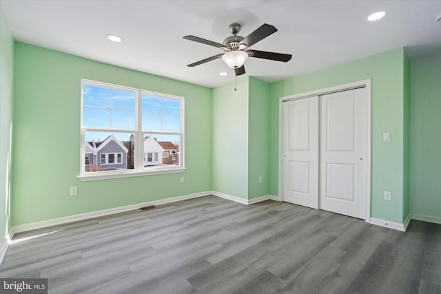 unfurnished bedroom with hardwood / wood-style floors, a closet, and ceiling fan