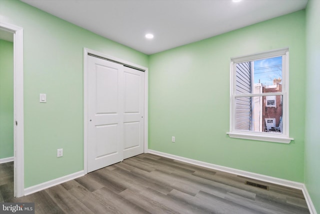 unfurnished bedroom featuring hardwood / wood-style floors and a closet