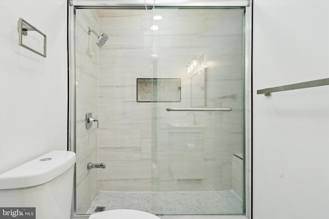 bathroom featuring an enclosed shower and toilet