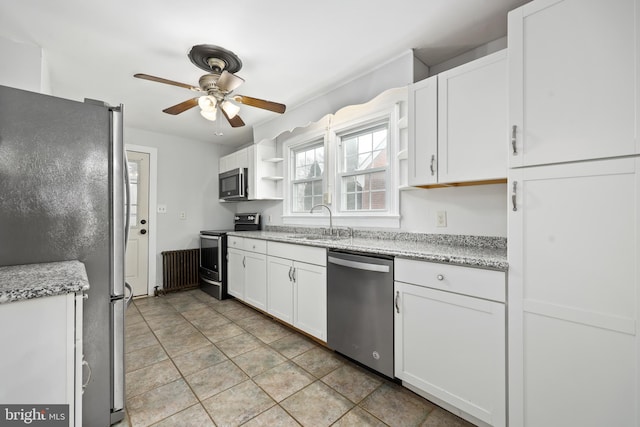 kitchen featuring ceiling fan, sink, light stone counters, white cabinets, and appliances with stainless steel finishes